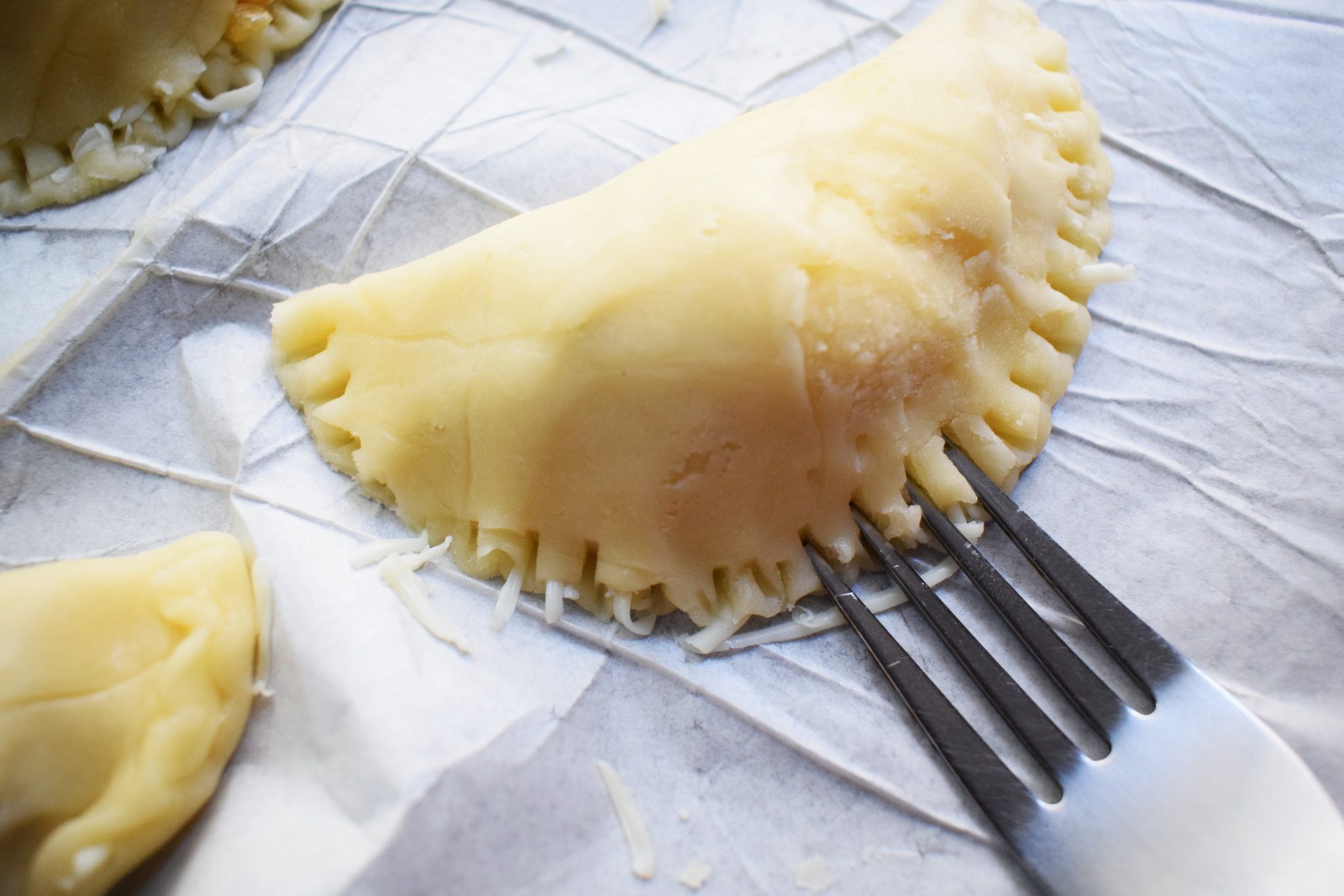 Fold the dough over the filling to create a half-moon shape