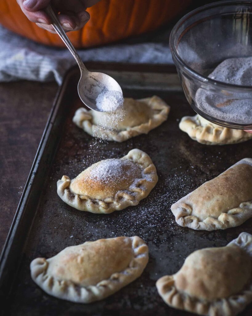 Sprinkle sugar on top of empanadas